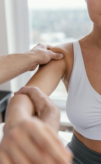 terapeuta-osteopata-masculino-verificando-ombro-de-paciente-sexo-feminino